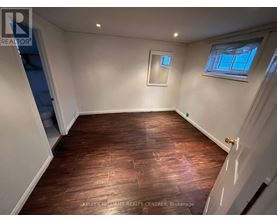 A room with wooden flooring and white walls.