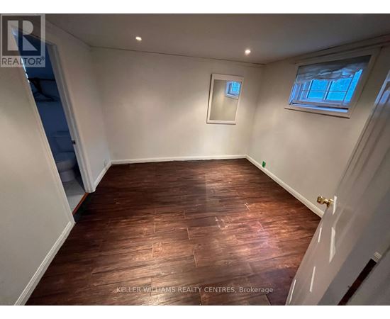 A room with wooden flooring and white walls.