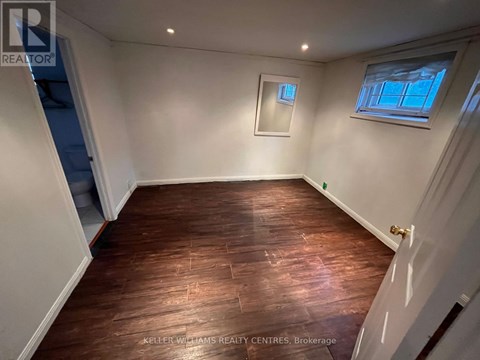 A room with wooden flooring and white walls.