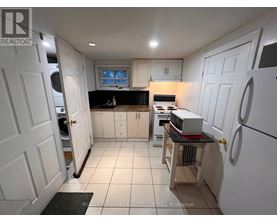 A kitchen with white cabinets and a black countertop.