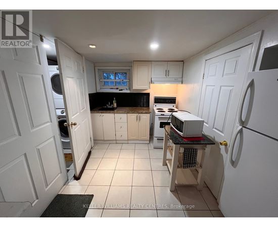 A kitchen with white cabinets and a black countertop.