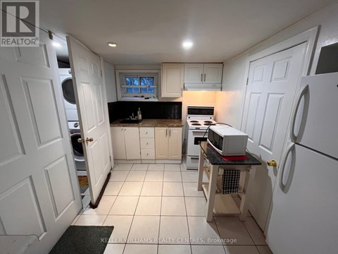 A kitchen with white cabinets and a black countertop.