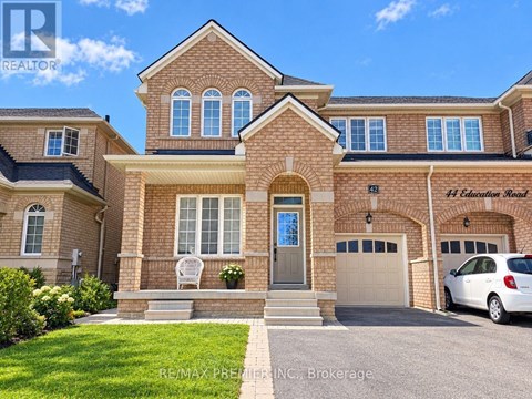 A large brick house with a car parked in front.