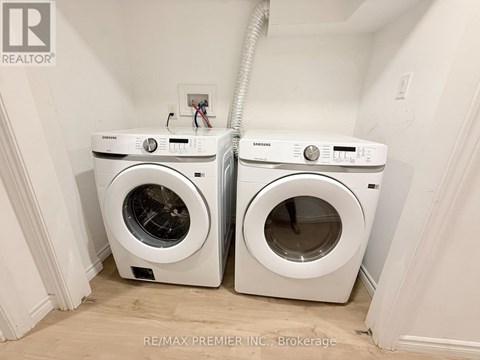 Two white front load washing machines in a laundry room.
