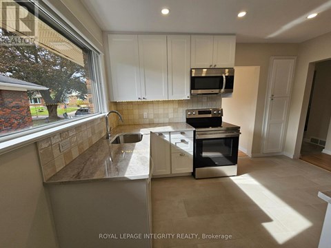 A kitchen with white cabinets and a black oven.