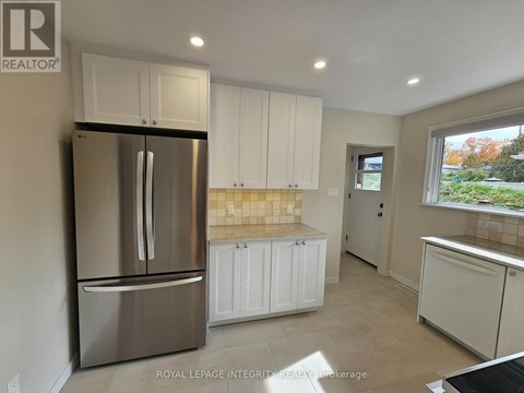 A kitchen with white cabinets and a stainless steel refrigerator.