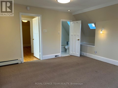 A room with a carpeted floor and a doorway leading to another room.