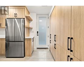A modern kitchen with a stainless steel refrigerator and wooden cabinets.