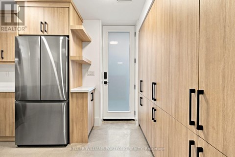 A modern kitchen with a stainless steel refrigerator and wooden cabinets.