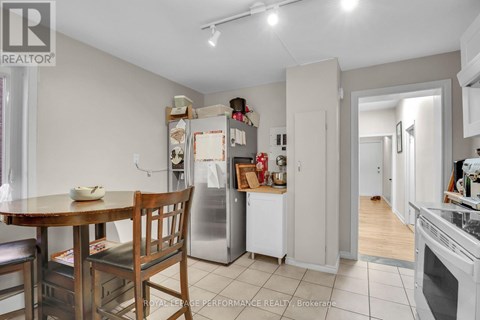 A kitchen with a table and chairs in the foreground and a refrigerator in the background.