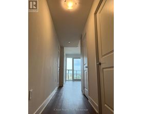 A long hallway with doors on both sides leading to a balcony.