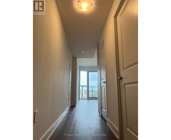A long hallway with doors on both sides leading to a balcony.