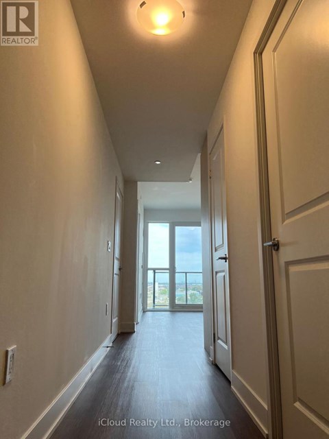 A long hallway with doors on both sides leading to a balcony.