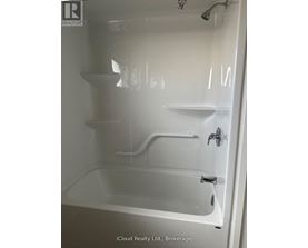 A white bathtub with a shower head and faucet.