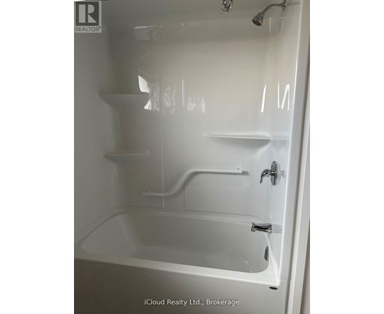 A white bathtub with a shower head and faucet.