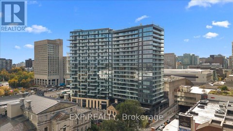 A tall building with many windows is the focal point of the image.