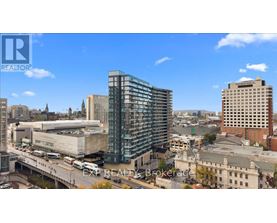 A cityscape with a modern glass building in the center.