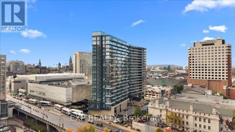 A cityscape with a modern glass building in the center.