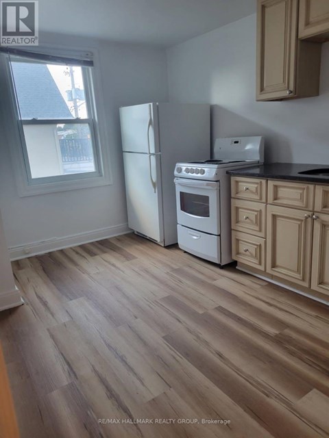 A kitchen with a white fridge, stove and oven.