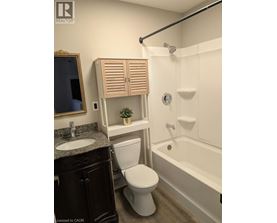 A white toilet sits next to a white bathtub in a bathroom.