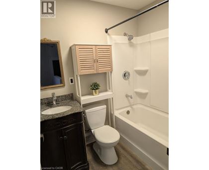 A white toilet sits next to a white bathtub in a bathroom.