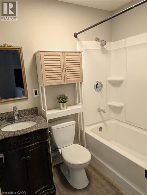 A white toilet sits next to a white bathtub in a bathroom.