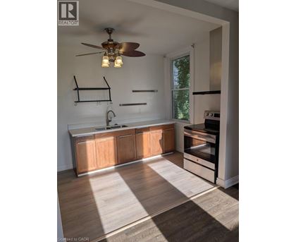A modern kitchen with wooden cabinets and a fan.