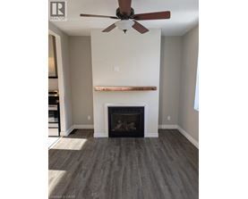 A living room with a fireplace and a ceiling fan.