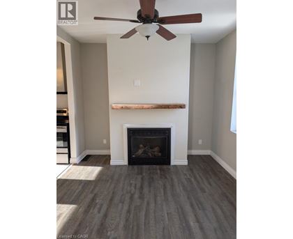 A living room with a fireplace and a ceiling fan.