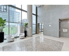 A large, modern office lobby with a grey carpet and white furniture.