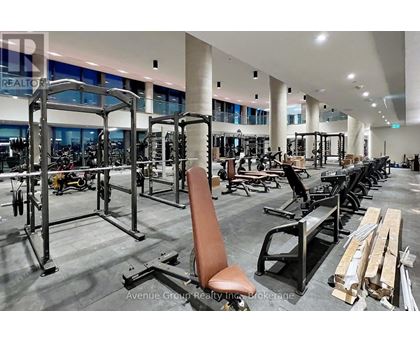 A gym with a variety of equipment including weight machines and free weights.