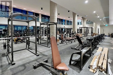 A gym with a variety of equipment including weight machines and free weights.