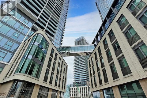 A view of a cityscape with tall buildings and a clear blue sky.