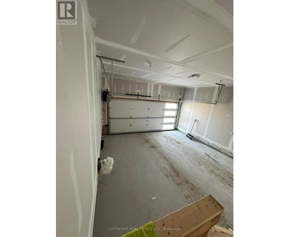 A room under construction with exposed pipes and unfinished walls.