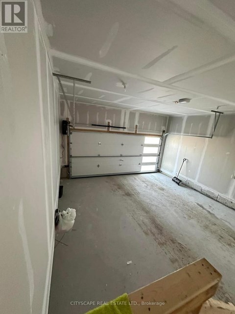 A room under construction with exposed pipes and unfinished walls.