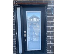 A black door with a glass window and a key in the lock.