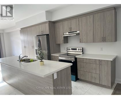 A modern kitchen with a white countertop and wooden cabinets.