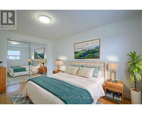 A bedroom with a large bed and a painting on the wall.