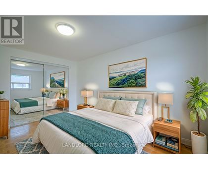 A bedroom with a large bed and a painting on the wall.