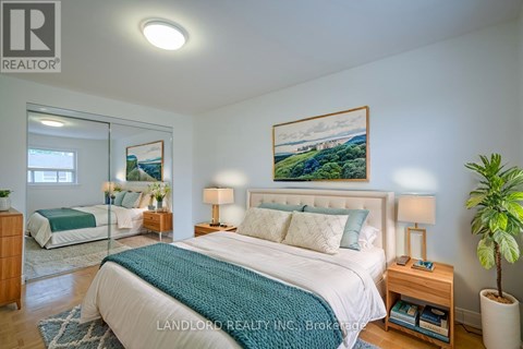 A bedroom with a large bed and a painting on the wall.