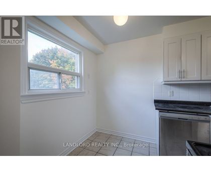 A kitchen area with a window and a stove top oven.