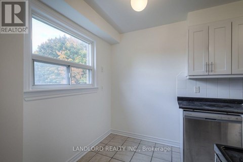 A kitchen area with a window and a stove top oven.