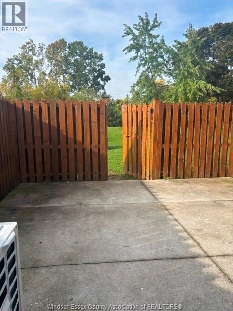 A brown wooden fence in front of a green field.