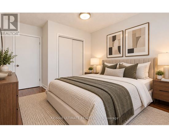 A bedroom with a large bed and two framed pictures on the wall.