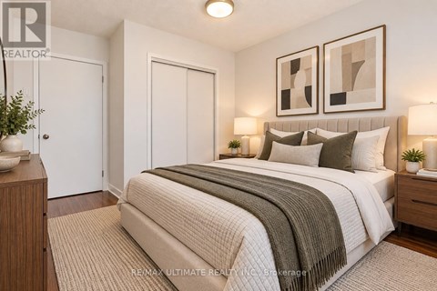 A bedroom with a large bed and two framed pictures on the wall.