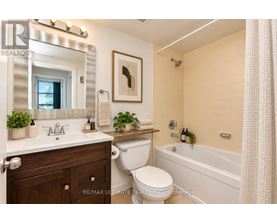 A bathroom with a white toilet, sink, and bathtub.