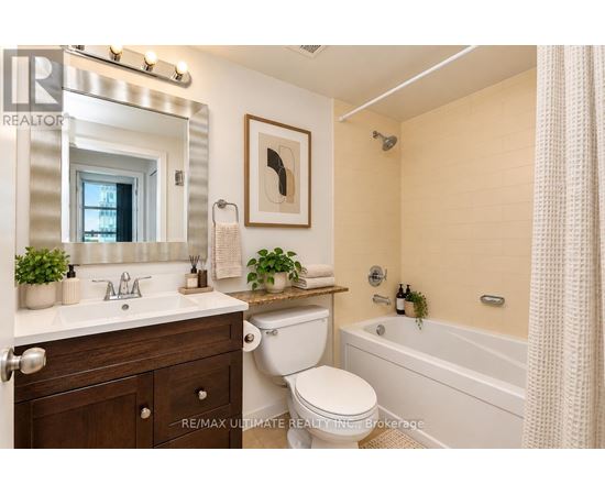 A bathroom with a white toilet, sink, and bathtub.
