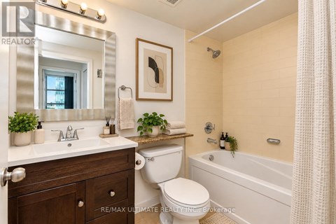 A bathroom with a white toilet, sink, and bathtub.