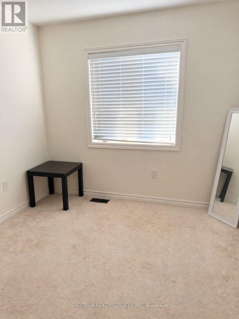 A room with a table, a window with blinds, and a mirror.