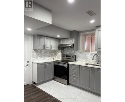 A modern kitchen with a stove top oven and a sink.